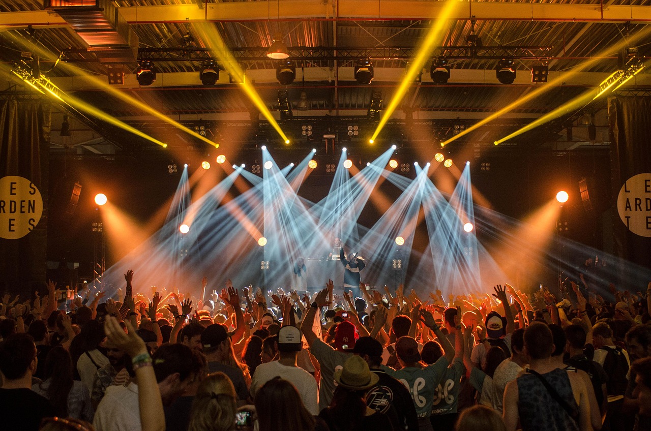Stage lighting beams over a live audience